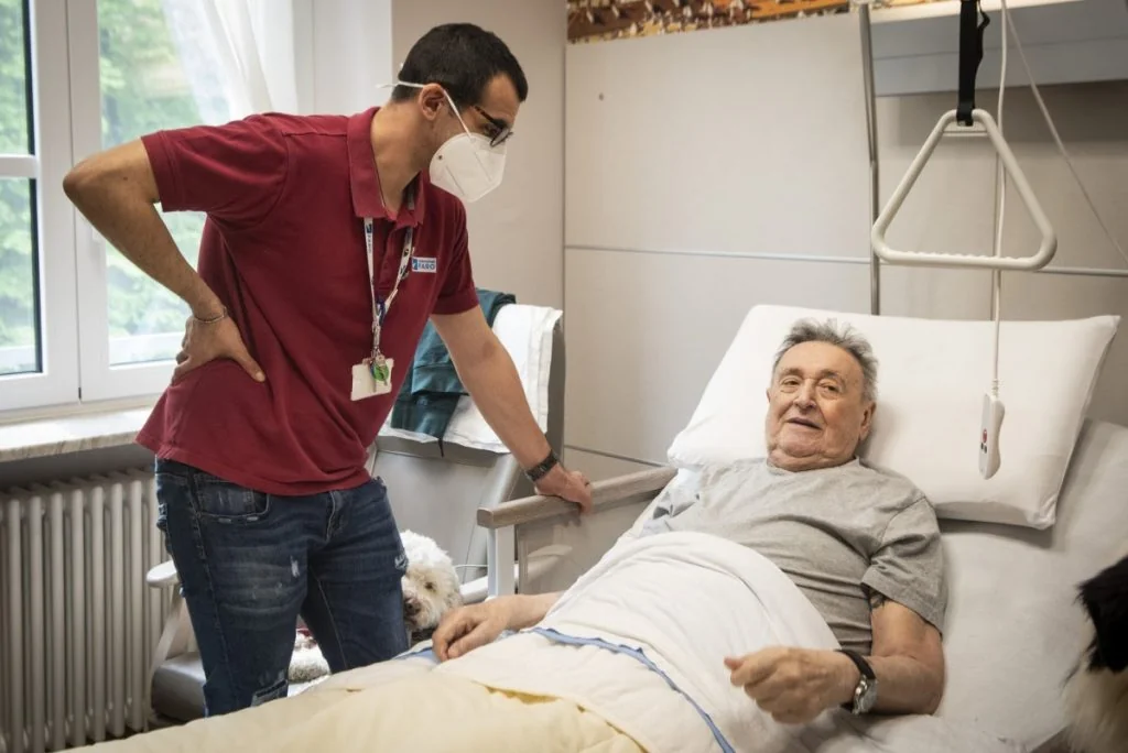 A Fondazione FARO carer beside a patient assisted at home